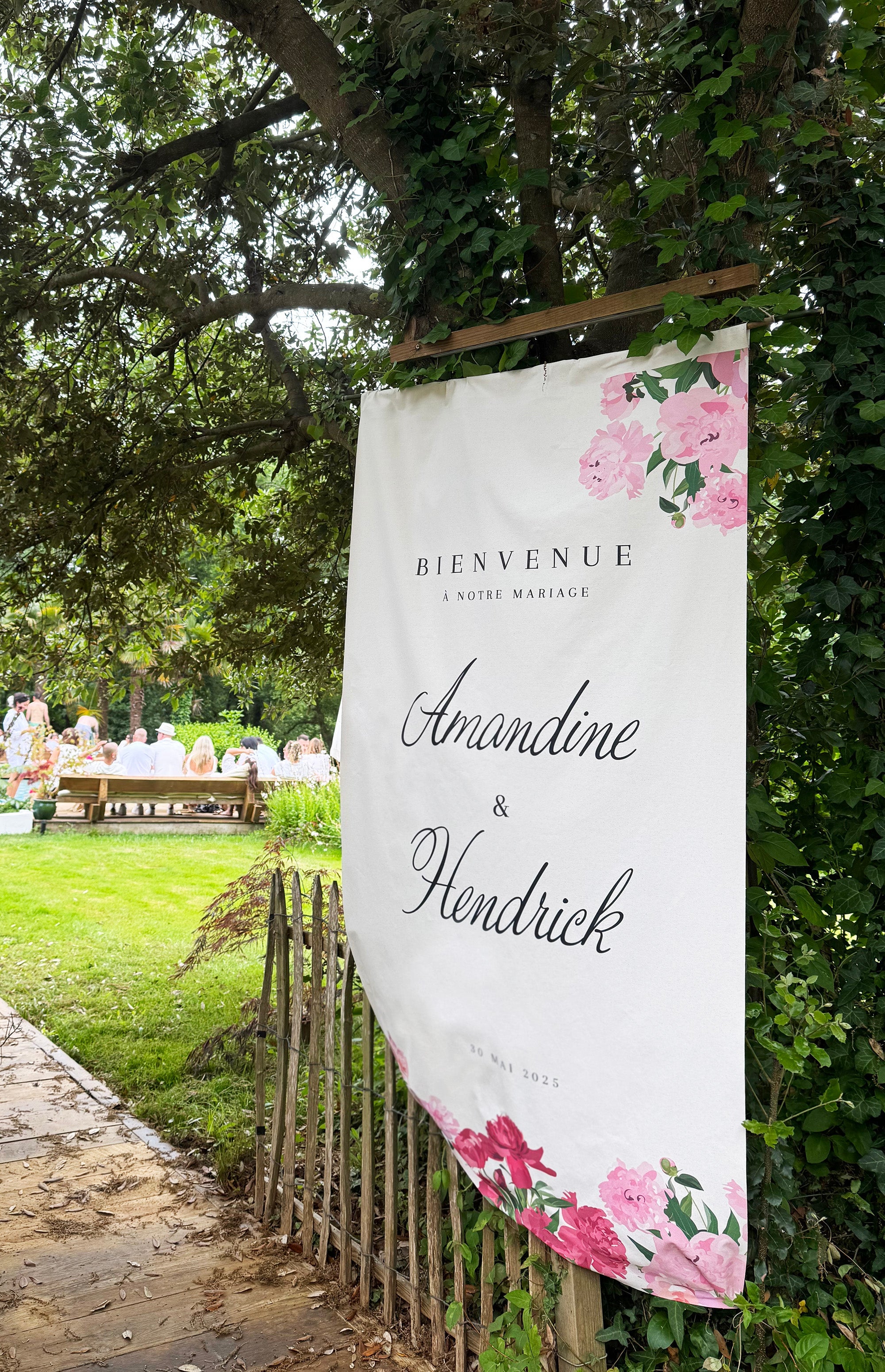 Panneau de bienvenue en lin décoré de pivoines, pour mariage élégant et fleuri.