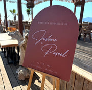 Panneau de bienvenue mariage en dibond, forme arche, couleur terracotta chaleureuse, parfait pour une déco moderne et bohème.