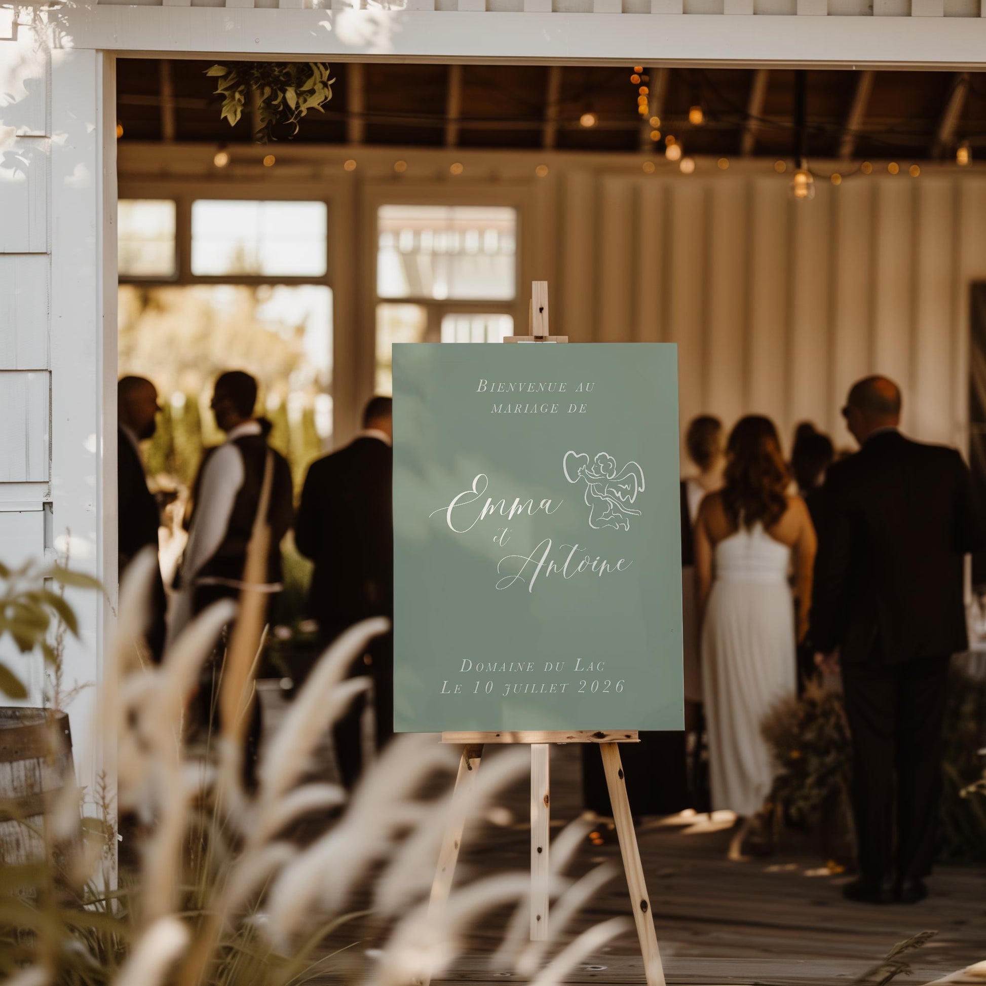 Panneau de bienvenue mariage fond vert sauge avec petit ange et calligraphie blanche