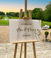 Panneau de bienvenue de mariage en plexiglass givré avec texte et fleur dorés, design minimaliste et élégant