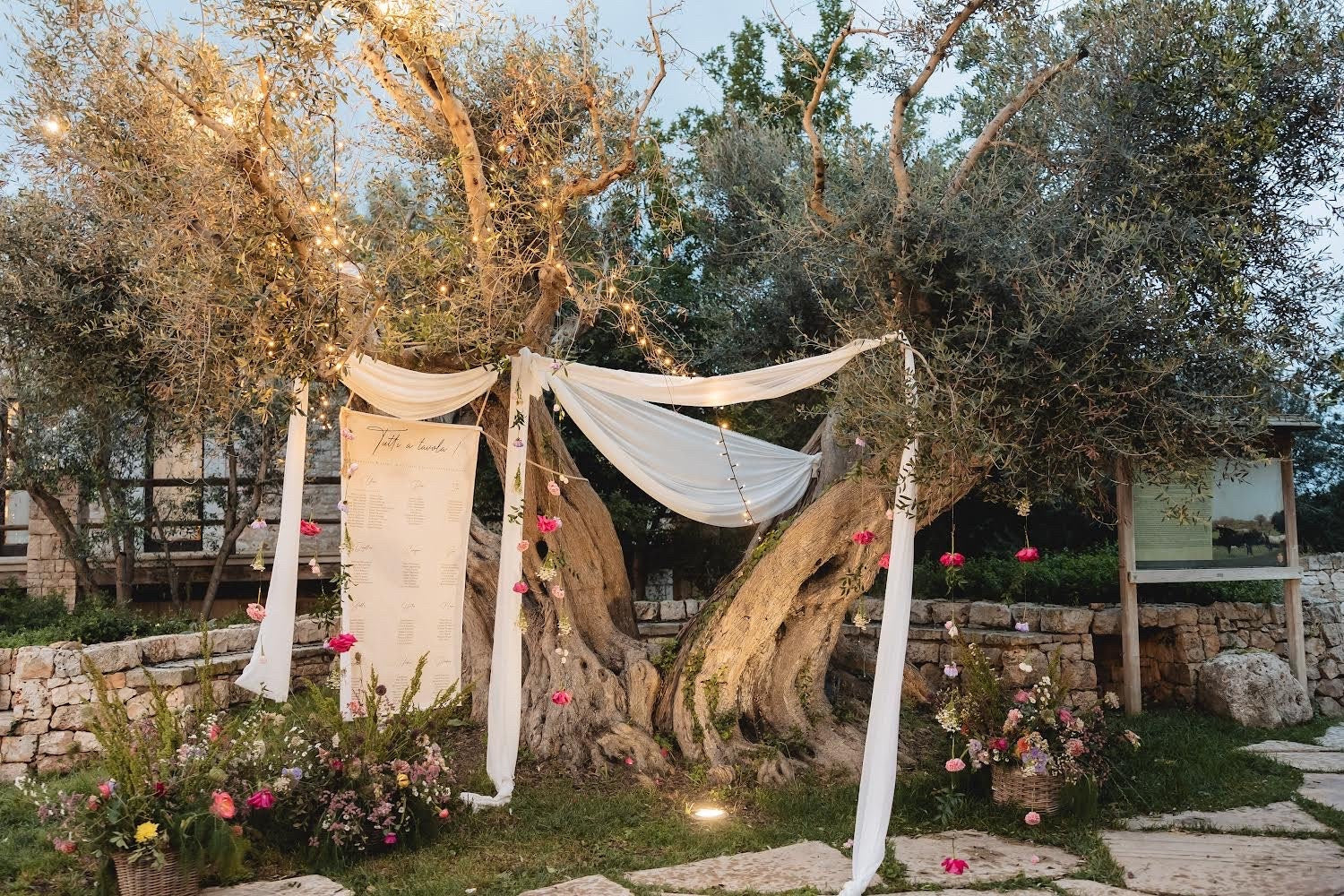 grand plan de table mariage en toile lin 12 tables, format vertical avec œillets dorés, accroché dans les arbres, design 2