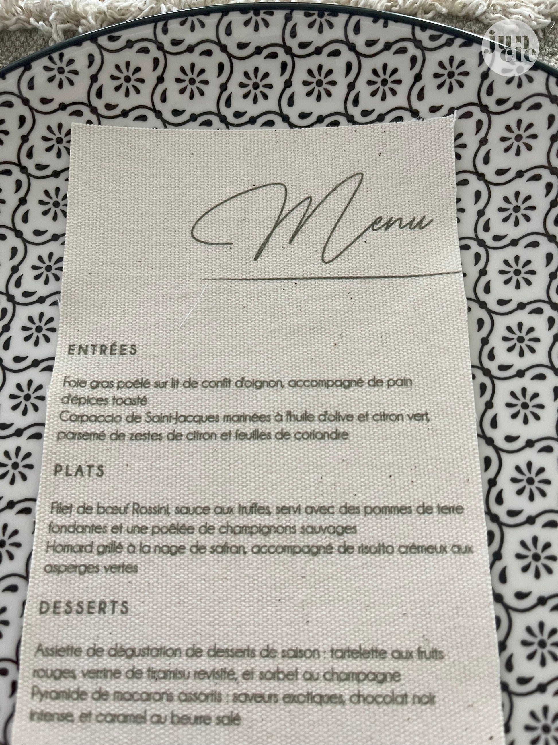 Gros plan sur le menu de mariage en lin, texture naturelle du tissu et impression raffinée du texte personnalisé.